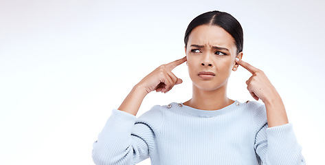 Image showing Annoyed, woman and finger in ears for noise, loud and denial gesture on studio white background. Omg, face and angry girl with complaint, ignoring and deaf, wtf and emoji, frustrated and unhappy