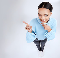 Image showing Happy mockup portrait, woman face and pointing at sales promotion, advertising copy space or discount deal mock up. Brand commercial, studio top view or product placement female on white background