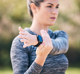 Image showing Serious, woman and stretching arms for exercise, training and sports in park. Focused female athlete warm up in workout, performance and fitness outdoors in nature, garden and muscle power for cardio