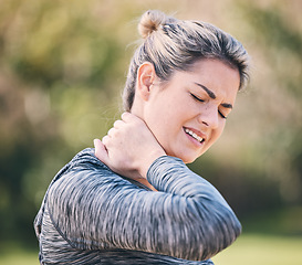 Image showing Fitness, injury and woman with neck pain in a park during running routine on blurred background. Spine, problem and girl suffering from injured muscle, arthritis or shoulder strain after workout run