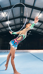 Image showing Woman, gymnastics and hoop for performance, sports training and dancing action in arena. Female, rhythmic movement and dancer with spinning ring for creative talent, solo concert or balance challenge