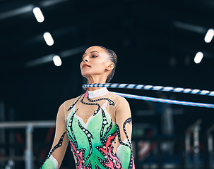 Image showing Woman, gymnastics and spinning hoop on neck for competition, sports training and action in arena. Female dancer, rhythmic movement and athlete with loop for dynamic solo concert, event or performance