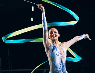 Image showing Ribbon gymnastics, happy woman and portrait of dancer in performance, training show and competition in dark arena. Female, rhythmic movement and smile for action, creative talent and sports concert