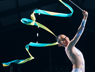 Image showing Ribbon gymnastics, happy woman and portrait of dancer in performance, training show and competition in dark arena. Female, rhythmic movement and smile for action, creative talent and sports concert