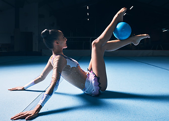 Image showing Woman, gymnastics and legs with ball for dancer performance, competition training or dark sports arena. Female athlete, rhythmic movement and creative talent in solo concert, agility skill or balance