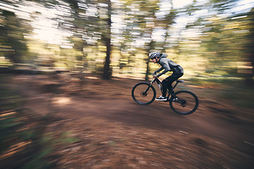 Image showing Bicycle, mountain bike and man cycling in the forest or woods fast, speed and adrenaline with motion blur. Extreme sports, actions and rider cycling for exercise, fitness and workout in nature