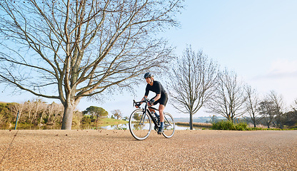 Image showing Sports, bicycle and woman cycling in a forest for fitness, exercise and morning cardio in nature. Training, bike and female enjoying workout in a park, freedom and energy, performance and endurance