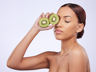 Image showing Beauty, skincare and kiwi with woman in studio for natural cosmetics, diet and nutrition. Product, glow and self care with female model and fruit on white background for spa, food and vitamin