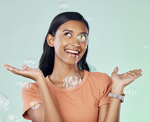 Image showing Happy, bubbles and smile with woman in studio for relax, carefree and cheerful emotion. Soap, happiness and light with female isolated on studio background for rainbow, wellness and art aesthetic