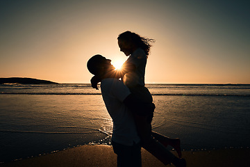 Image showing Love, silhouette and sunset with couple at beach for romance, affectionate and summer. Travel, happy and vacation with man and woman hugging for anniversary date, marriage and support on holiday