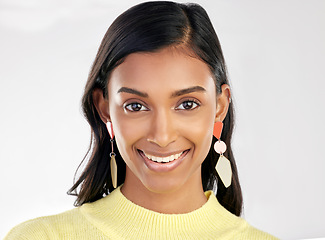 Image showing Portrait, fashion and beauty with a woman on a white background in studio wearing earrings or accessories. Face, smile and happy with an attractive young indian female closeup for contemporary style