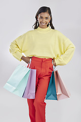 Image showing Portrait, shopping and sale with a woman customer in studio on a gray background for retail or consumerism. Fashion, luxury or bags with a female consumer or shopper standing hands on hips for deals