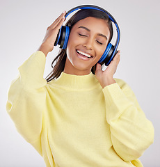 Image showing Woman with headphones, listening to music and happy on studio background with freedom, fun and peace. Smile, carefree and technology with entertainment, Indian female and radio streaming playlist