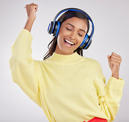 Image showing Woman with headphones, listen to music and happy on studio background with freedom, fun and peace. Smile, carefree and technology with entertainment, Indian female and radio streaming playlist