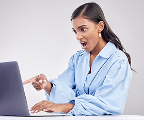 Image showing Shock, laptop and a pointing business woman in shock on a white background in studio while working. Wow, computer and hand gesture with a surprised female employee looking at an online notification