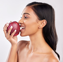 Image showing Woman, apple with face profile and health with nutrition and fruit, healthy food and diet on studio background. Weight loss, organic and fresh produce with happy female eating, wellness and lifestyle