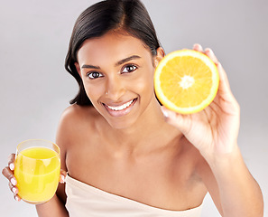 Image showing Happy woman, orange juice and fruit in portrait, health and nutrition with healthy drink and diet on studio background. Weight loss, organic and citrus beverage, vitamin c and female with wellness