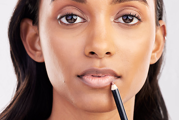 Image showing Woman, face closeup and portrait with lip liner makeup, beauty and cosmetic product on studio background. Indian female, cosmetics pencil for lips and lipstick with healthy skin and cosmetology