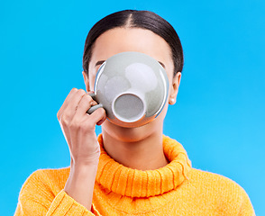 Image showing Coffee drinking, woman and studio with morning latte, mug and hot beverage. Isolated, blue background and female model or young person with casual fashion and ceramic cup for tea drink or cappuccino