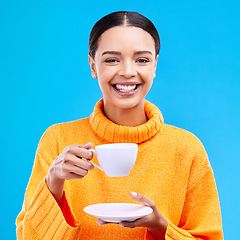 Image showing Tea, woman portrait and smile in studio with happiness, latte or matcha mug. Isolated, blue background and happy female model or young person smiling with casual winter fashion, joy and coffee drink