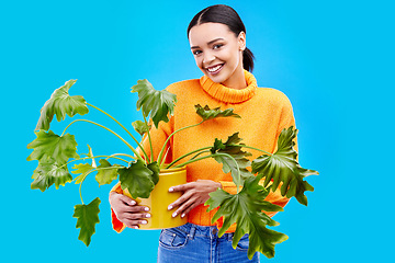 Image showing Portrait of happy woman in studio with plant, smile and happiness with house plants on blue background. Gardening, sustainable and green hobby for gen z girl on mockup for eco friendly garden shop.
