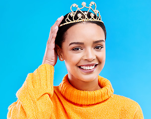 Image showing Pride, crown and portrait of woman in studio for celebration, princess and party. Smile, beauty and fashion with female and tiara on blue background excited for achievement, winner and prom event