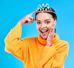 Image showing Pointing, crown and portrait of woman in studio for celebration, princess or wow party. Smile, beauty or fashion with female tiara on blue background excited for achievement, winner and prom surprise