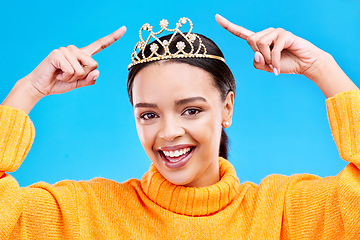 Image showing Point, crown or portrait of woman in studio celebration, princess and birthday party. Smile, beauty and fashion with female tiara on blue background and excited for achievement, winner and prom event