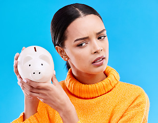 Image showing Piggy bank, investment and woman in a studio saving her money for financial growth or profit. Banking, budget and female model with a cash investing plan with finance knowledge by a blue background.