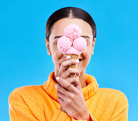 Image showing Ice cream, cover and hide with woman in studio for snack, dessert and sweets. Diet, summer and junk food with female and frozen gelato isolated on blue background for sugar, nutrition and mockup