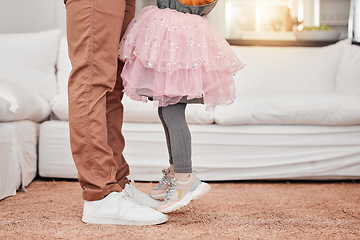 Image showing Feet of father and child dancing in the living room of their modern family home to music or radio. Dance, energy and closeup of man bonding, having fun and standing with his daughter in their house.