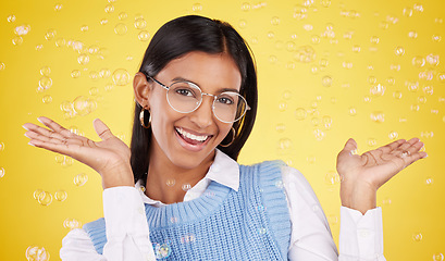 Image showing Happy, bubbles and portrait of a woman in a studio with glasses for eye care, optical wellness and health. Happiness, smile and female model with spectacles and positive mindset by yellow background.