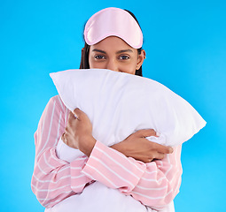 Image showing Portrait, pillow and woman in pajamas, happy and ready for sleeping against isolated blue studio background. Face, female and person with sleepwear, eye mask and calm with happiness and cushion hug