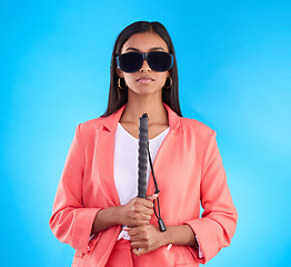 Image showing Blind, face and woman with disability in a studio with guide cane for eyes impairment help. Glasses, serious or young female person in post eye surgery on isolated blue background with vision problem