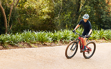 Image showing Sports, nature and woman cycling on a bicycle while training for a race, marathon or competition. Fitness, workout and female athlete cyclist doing cardio exercise on a bike on outdoor trail in park.