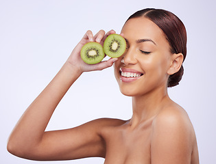 Image showing Happy, skincare and kiwi with woman in studio for natural cosmetics, diet and nutrition. Product, glow and self care with female model and fruit on white background for spa, food and vitamin