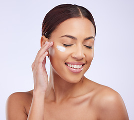 Image showing Face cream, skincare and woman in studio for cosmetic, treatment and dermatology on purple background. Facial, lotion and sunscreen for happy lady model relax with spf, moisturiser or beauty routine