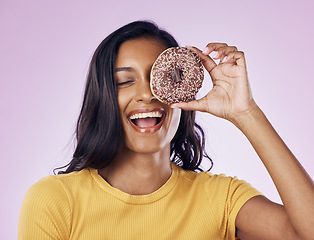 Image showing Donut, laughing and cover with woman in studio for diet, snack and happiness. Sugar, food and smile with female hiding and isolated on pink background for nutrition, playful and craving mockup