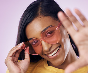 Image showing Heart, sunglasses and indian woman selfie in studio happy, cheerful and fun on purple background. Glasses, portrait and female gen z fashion influencer smile for profile picture, photo or blog post