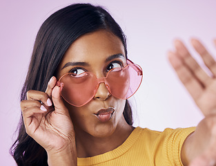 Image showing Selfie, heart and sunglasses by indian woman in studio emoji, cool and fun on purple background. Glasses, trendy and female gen z fashion influencer posing for profile picture, photo or blog post