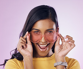 Image showing Portrait, sunglasses and cool woman excited, happy and confident isolated in a pink studio background with joy. Fashion, vision and young gen z female with new frames, eyewear or glasses