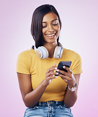 Image showing Music, phone and Indian woman typing on pink background for social media, website and chatting. Relax, happy and isolated girl streaming audio, radio and track on smartphone for message on mobile app