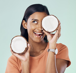 Image showing Beauty, face and happy woman with studio coconut for natural skincare, organic cosmetics or eco friendly makeup. Vitamins, health benefits and excited female with fruit product on green background