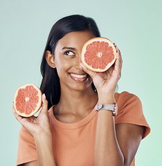 Image showing Studio beauty, face and happy woman with grapefruit for natural skincare, health and wellness routine. Fruit detox, vitamin c benefits and nutritionist person with citrus product on green background