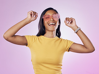 Image showing Dance, sunglasses and happy woman excited, cool and confident isolated in a pink studio background with joy. Singing, music and young gen z female dancing celebration of a party energy with glasses