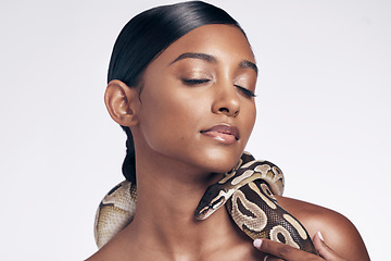 Image showing Skincare, studio and woman with snake on neck for art aesthetic with exotic zoo animal on white background. Face, danger and creative style, Indian beauty model with seductive look and dangerous pet.