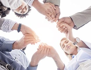 Image showing Business people, holding hands and teamwork for collaboration, trust or unity below in the outdoors. Group of employees touching hand together for community, team building or partnership in nature