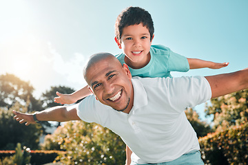 Image showing Portrait, piggyback and a son flying on the back of his father outdoor in the garden while bonding together. Family, children or love and a boy playing with his dad in the backyard of their home