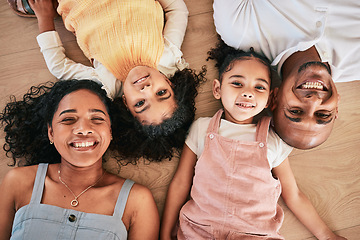 Image showing Portrait, above and happy family on a floor, smile and bonding in a living room together. Top view, love and face of children with parents, relax and cheerful while having fun, lying and chilling