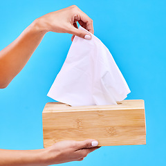 Image showing Tissue, blue background and hands with box for handkerchief for flu, sickness and sinus mockup. Healthcare, toiletries and woman with hygiene wipe, napkin and paper for cleaning, allergy and sneeze